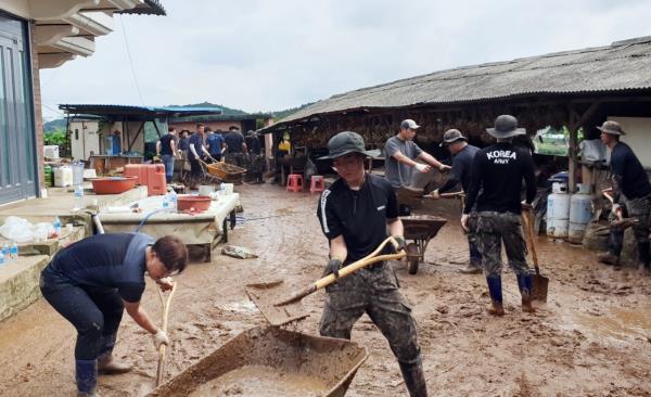 军队士兵在忠南清阳郡的一户人家清除因连日暴雨而留下的泥土。(联合通讯社)