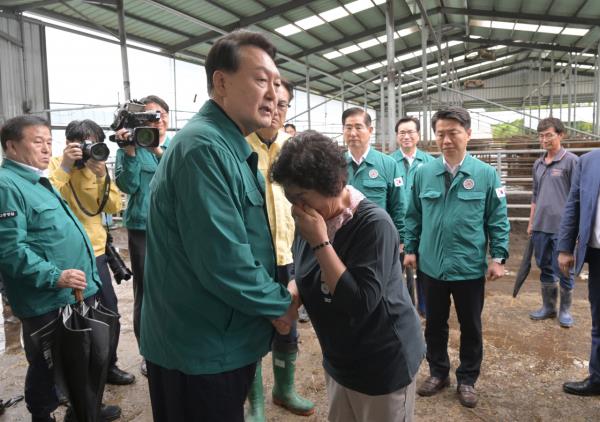 President Yoon Suk Yeol (front, left) consoles a villager during a visit to Gongju on Tuesday (Yonhap)