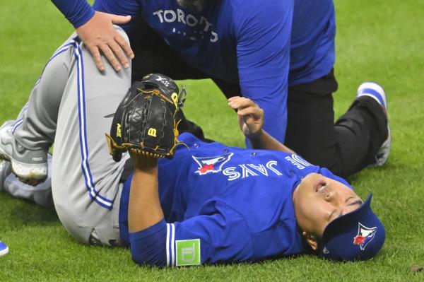 Ryu Hyun-jin of the Toronto Blue Jays is attended to by a team trainer after taking a line drive off his right knee during the bottom of the fourth inning of a Major League baseball regular season game against the Cleveland Guardians at Progressive Field in Cleveland on Monday. (Reuters)