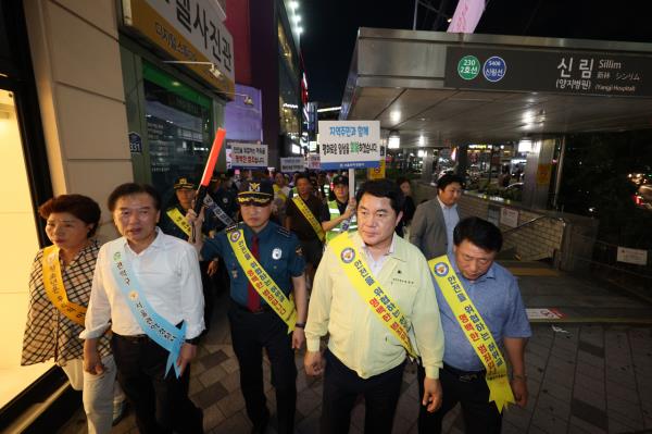 相关组织包括冠岳警察署、地方商会和志愿夜间巡逻队于周一在首尔冠岳区新林洞开展了一项犯罪预防活动。(联合通讯社)