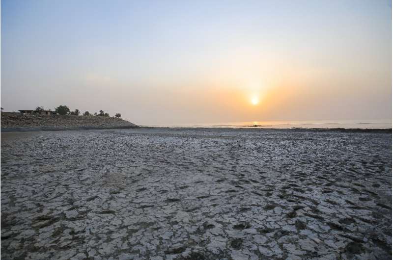 To get to the water, visitors must walk through foul-smelling mud that was once submerged under the lake surface